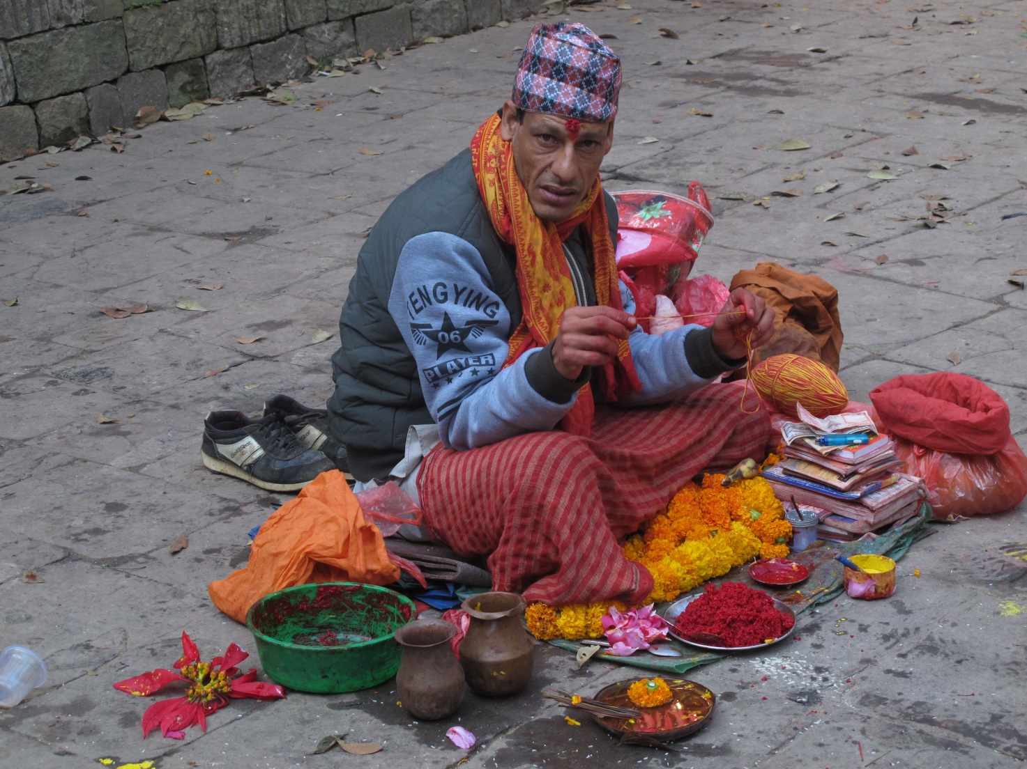 Nepal,Kathmandu Uno dei tanti nepalesi che vende offerte propiziatorie e che applica la “tilaka”