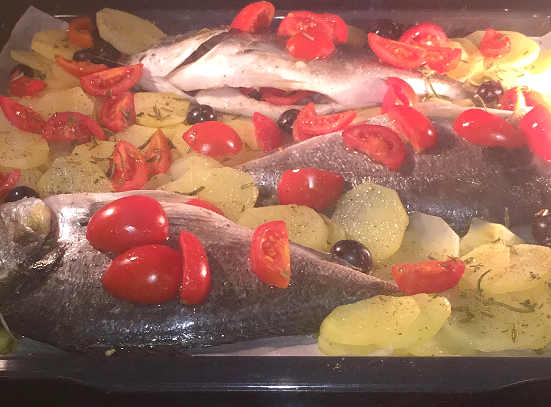 Preparazione dell'Orata al forno con patate, pomodori e olive dolci