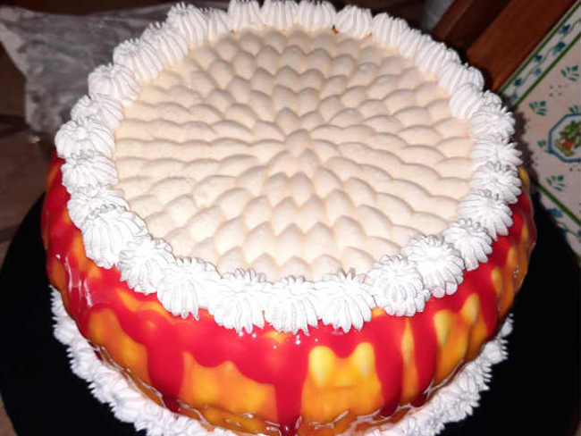 torta decorata con glassa rossa e panna 